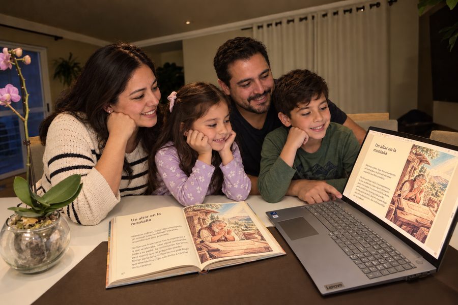 Familia completa leyendo junta alrededor de la mesa